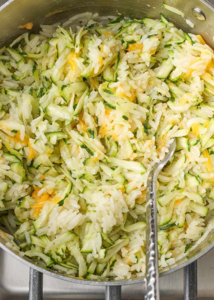 cheesy zucchini rice in pot with fork