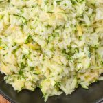 Zucchini Rice with butter and cheese in black bowl