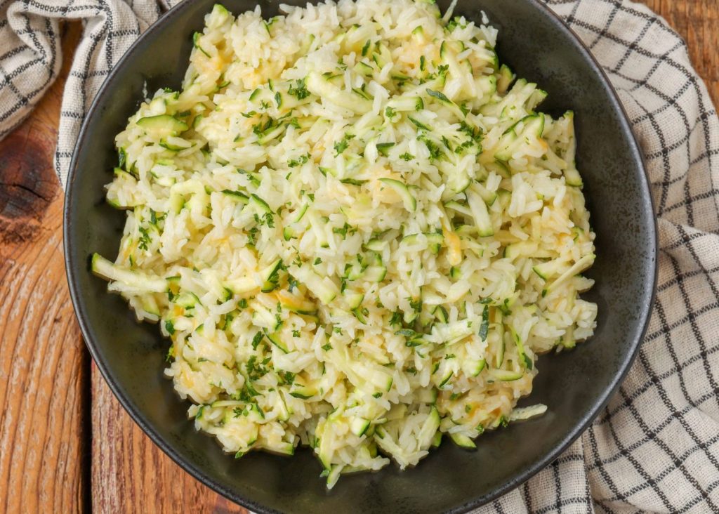 cheesy rice with zucchini in black bowl