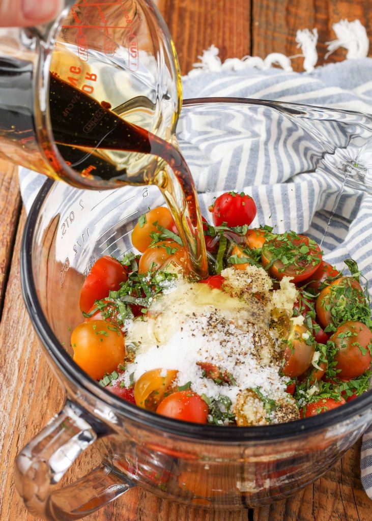 balsamic vinegar is poured over the tomatoes in this image