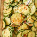 close up spoonful of cucumber salad with dressing