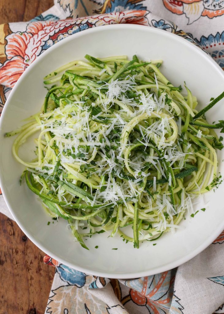 zucchini in white bowl topped with parmesan