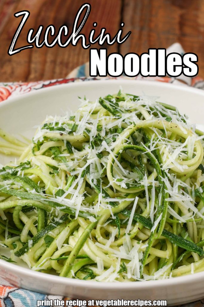 zucchini noodles tossed with parmesan in white bowl over floral napkin