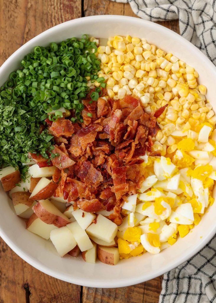 Potato salad ingredients with bacon, corn, egg, cilantro, and green onion