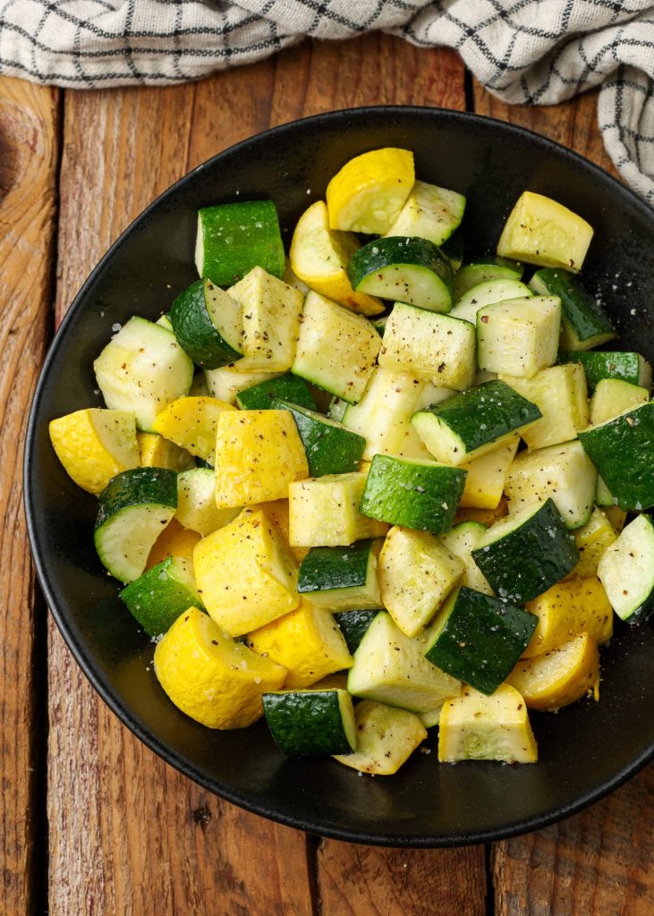 black serving dish holding chunks of cooked zucchini