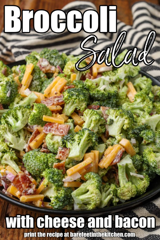 Overhead shot of broccoli cheese bacon salad in a glass bowl with a striped black and white towel