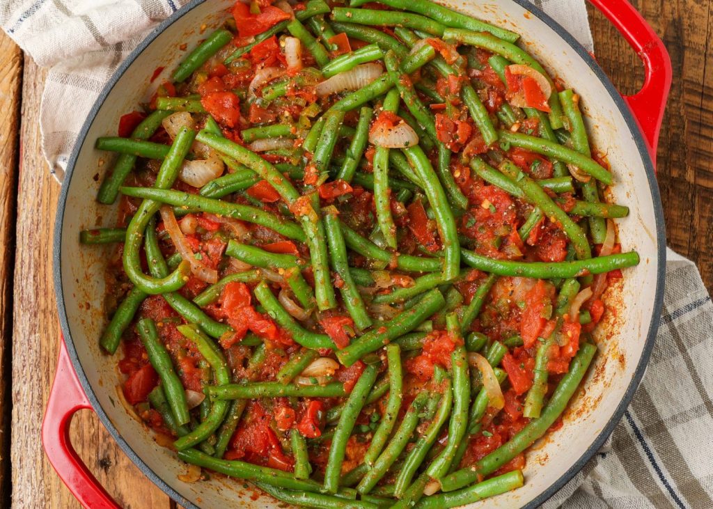 green beans with tomatoes, jalapenos and onions in a skillet
