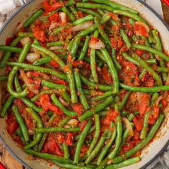 green beans with tomatoes, jalapenos and onions in a skillet