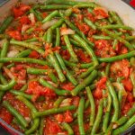 saucy green beans with tomatoes in enameled skillet