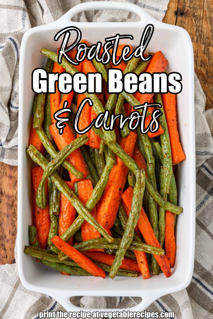 Vertical shot of roasted carrots and green beans in a long white tray