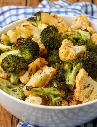 close up of broccoli and cauliflower in white bowl with blue cloth