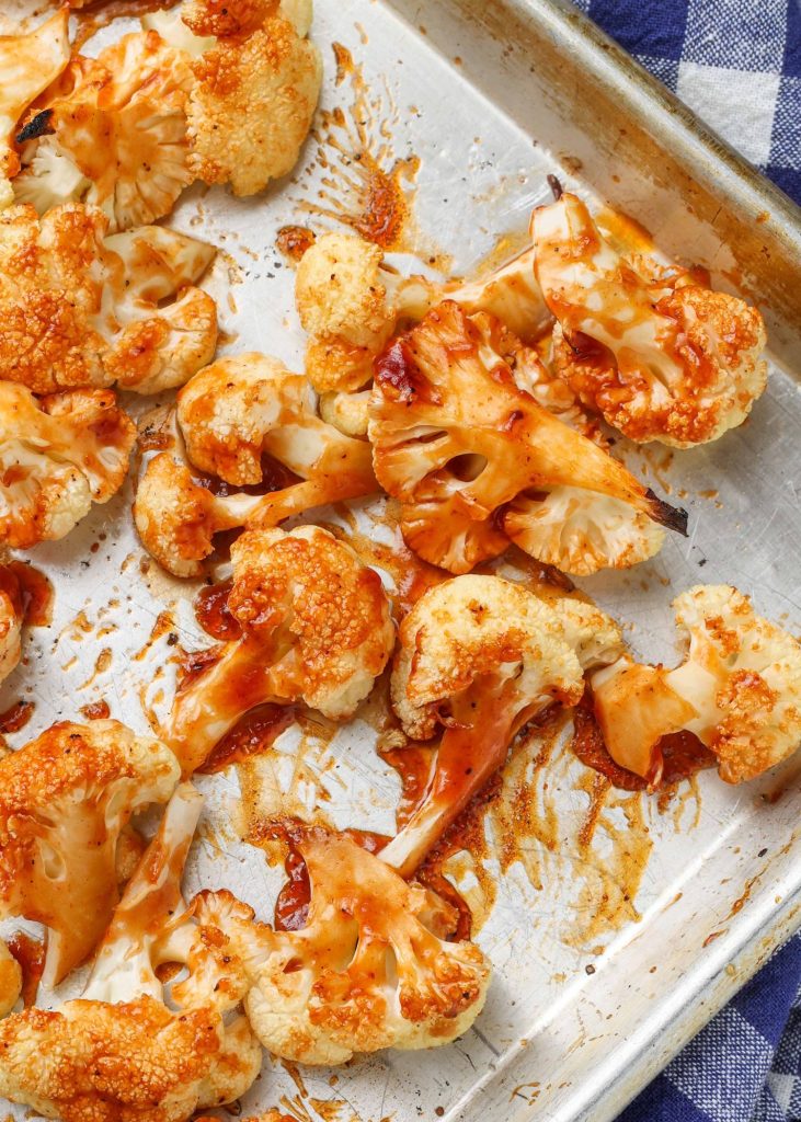 roasted cauliflower with bbq sauce is fresh from the oven on a metal sheet pan