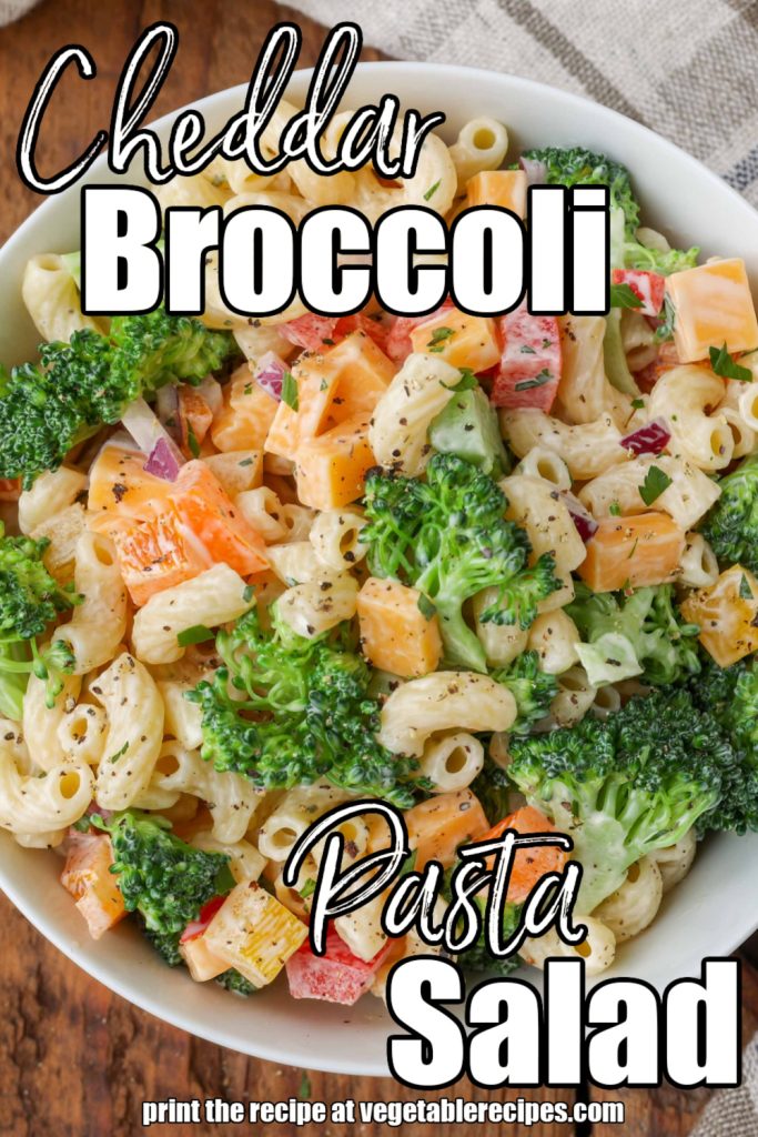 Overhead vertical shot of broccoli pasta salad, served in a white bowl with a checkered white and gray towel