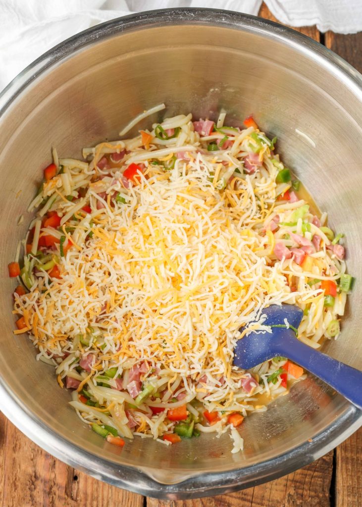a mountain of shredded cheese has been placed atop the ingredients in the mixing bowl