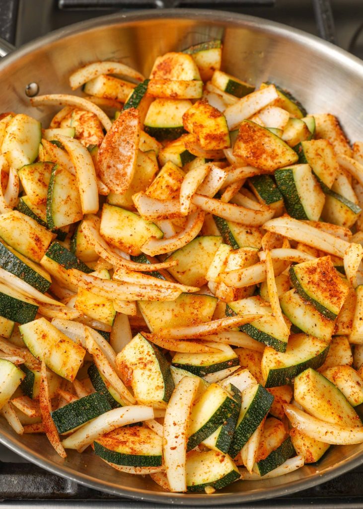 The zucchini and onions have been transferred to a metal pan, ready to cook.