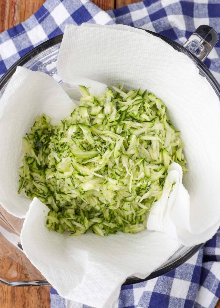 shredded zucchini on paper towels in bowl
