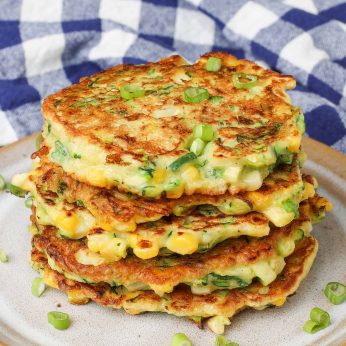 close up of stacked fritters with zucchini, corn, and green onions