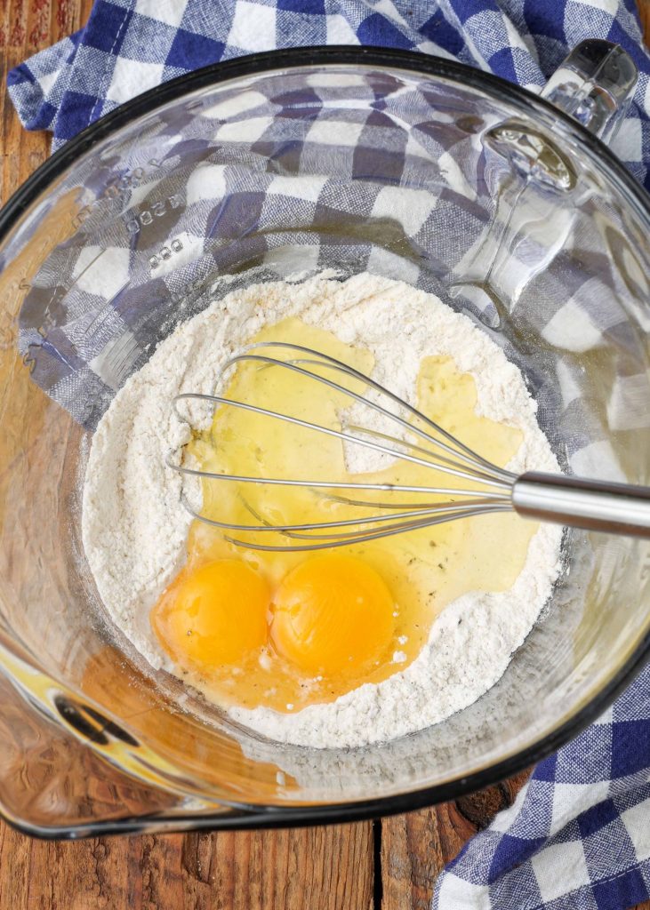 flour with egg in bowl with whisk
