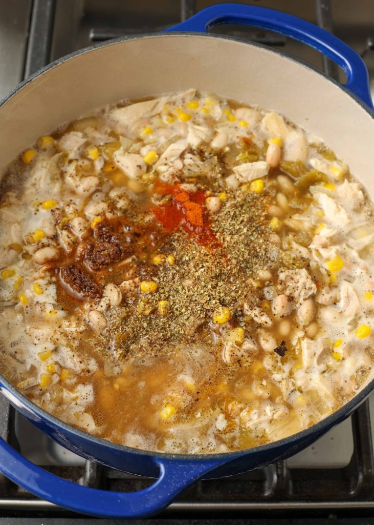 corn, chicken, and white beans, broth, and seasonings in blue pot