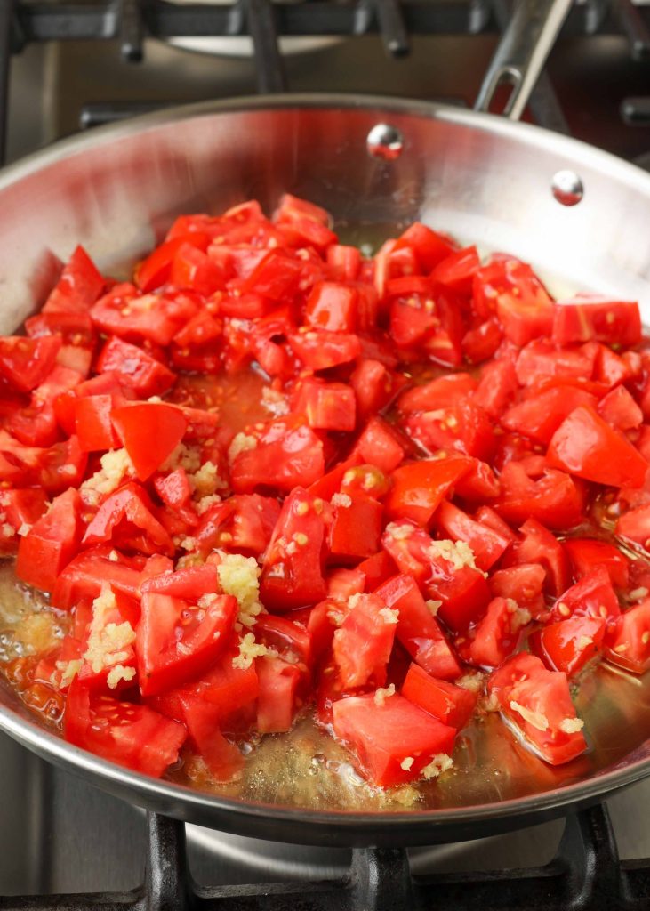 Cooking the tomatoes and garlic in a metal pan