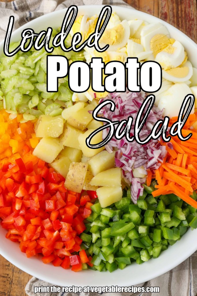 White lettering has been overlaid this top down image of a large white bowl filled with the arranged ingredients for a vegetable potato salad. It reads, "Loaded Potato Salad".