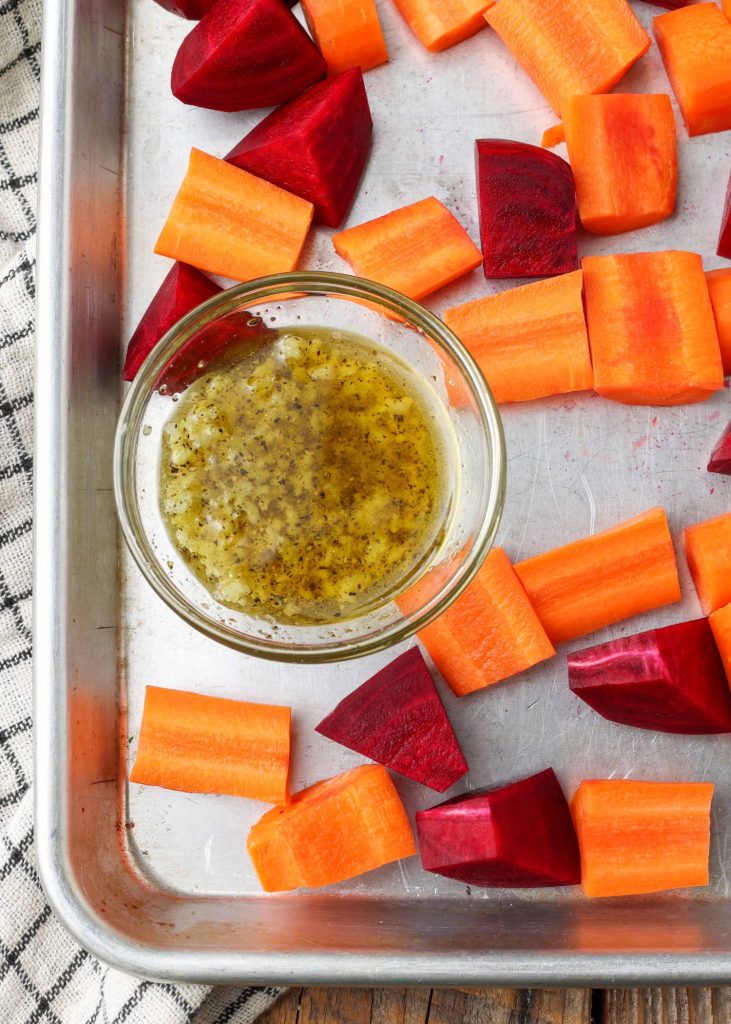 raw carrots and beets on sheet pan with oil and garlic