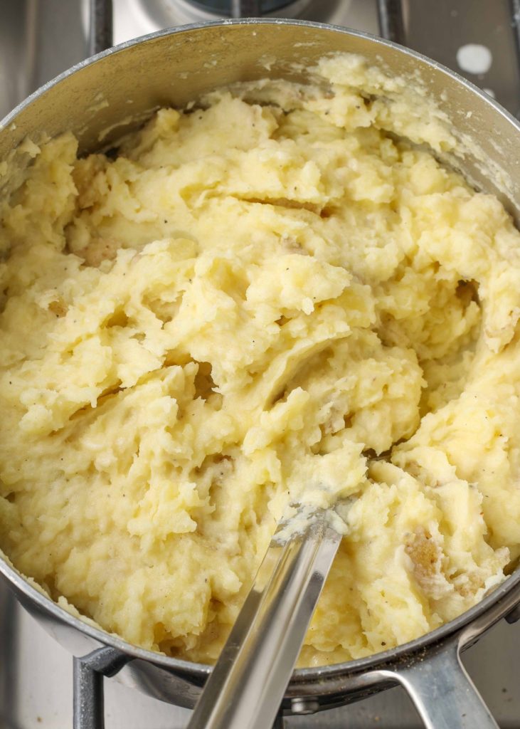 Overhead shot of creamy mashed potatoes in a silver pot