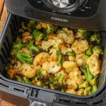 cooked broccoli and cauliflower in air fryer basket