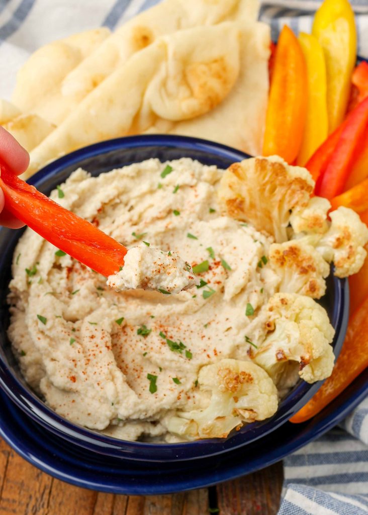 red bell pepper strip dipped into hummus