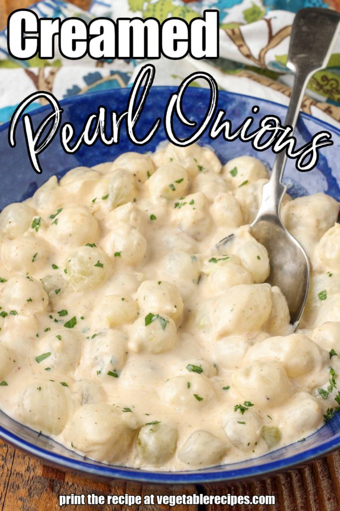Overhead vertical shot of creamed pearl onions in blue bowl with silver spoon; the words "Creamed Pearl Onions" are superimposed over the image