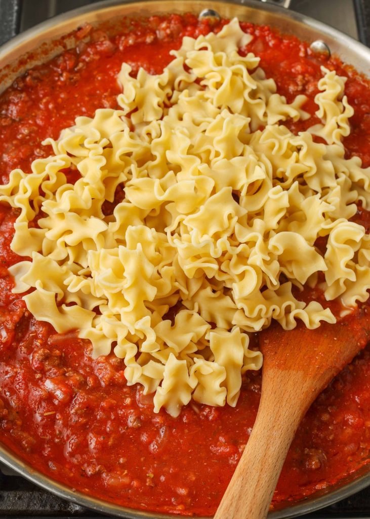 Pasta has been placed on top of the meat sauce in this photo.
