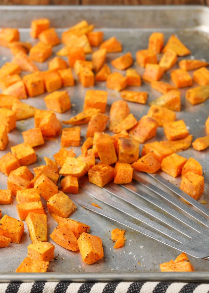 roasted sweet potatoes on sheet pan with spatula