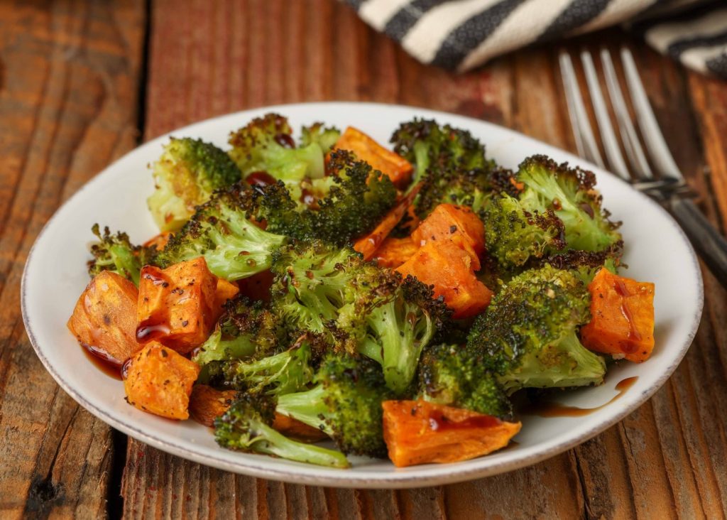 broccoli and sweet potatoes on white plate with fork