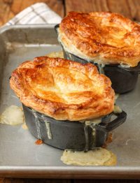 golden brown pastry topped pot pies dripping on pan