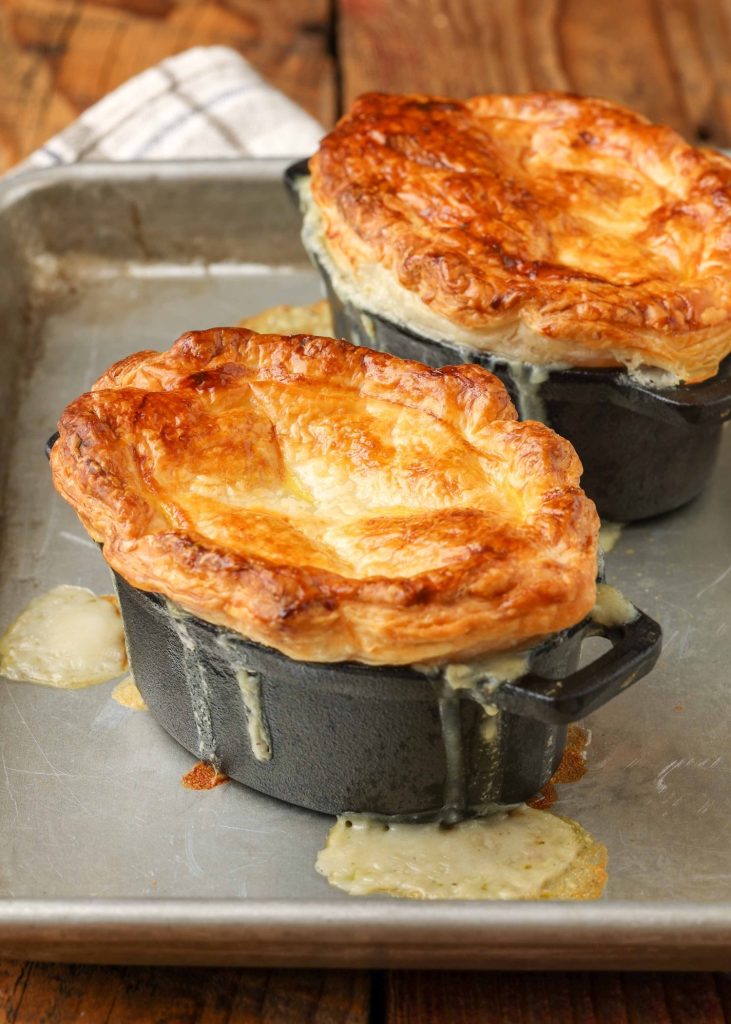 golden brown pastry topped pot pies dripping on pan