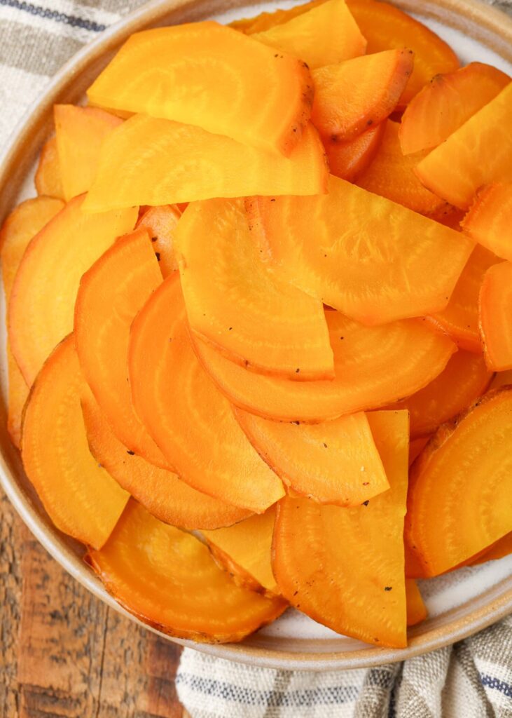 Sliced golden beets in a white bowl