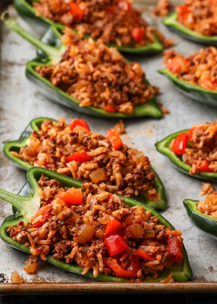 rice and beef mixture filling poblano peppers on baking tray