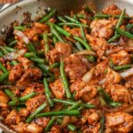 large skillet holding a stir fry with chicken and green beans