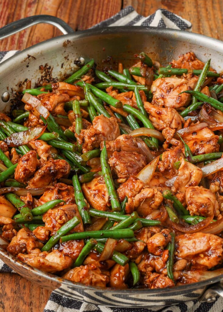 large skillet holding a stir fry with chicken and green beans