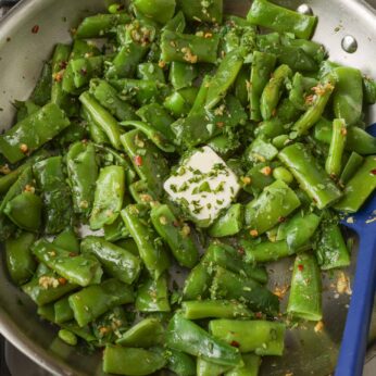 Sizzling green beans and butter in stainless steel skillet