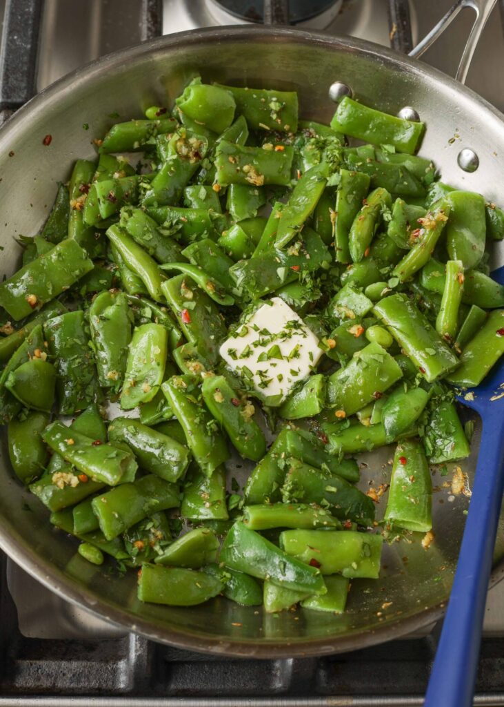 Sizzling green beans and butter in stainless steel skillet