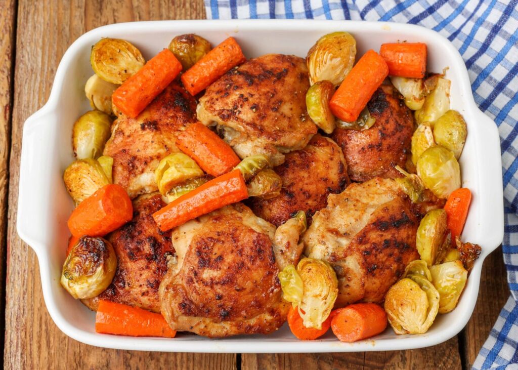 Chicken with Carrots and Brussels sprouts in white baking dish