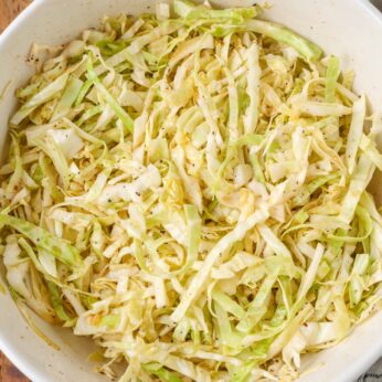 spicy cabbage slaw tossed in white bowl