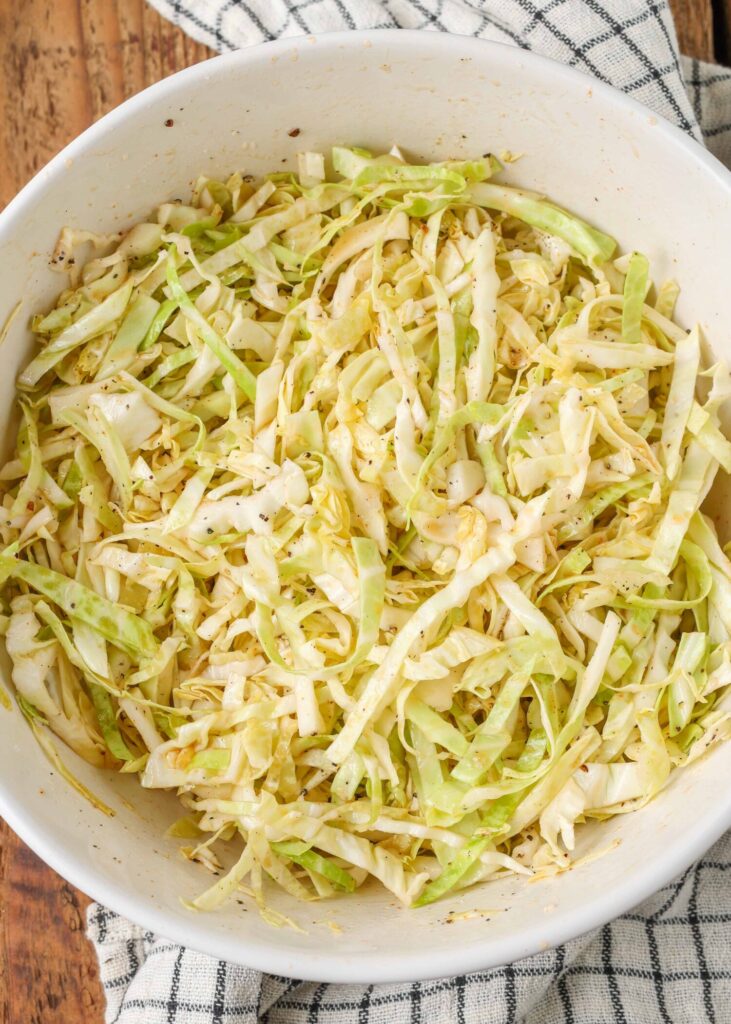 spicy cabbage slaw tossed in white bowl