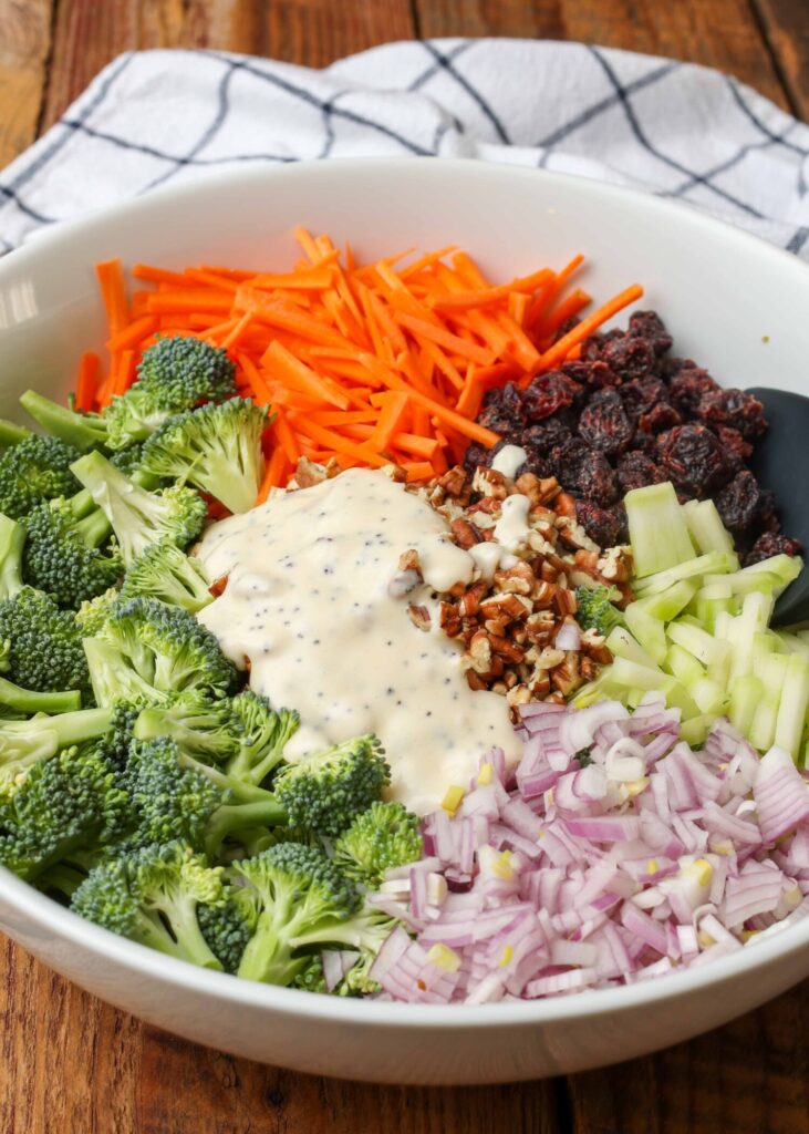 dressing poured over salad ingredients in white bowl