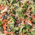 close up of salad with broccoli, carrots, red onion, cranberries, and pecans