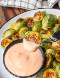 Brussels sprout on fork with bang bang sauce