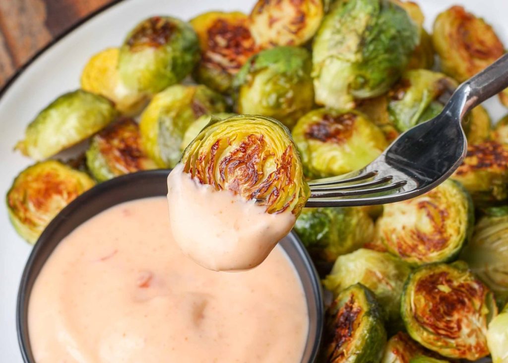 roasted Brusssels sprout on fork with dipping sauce