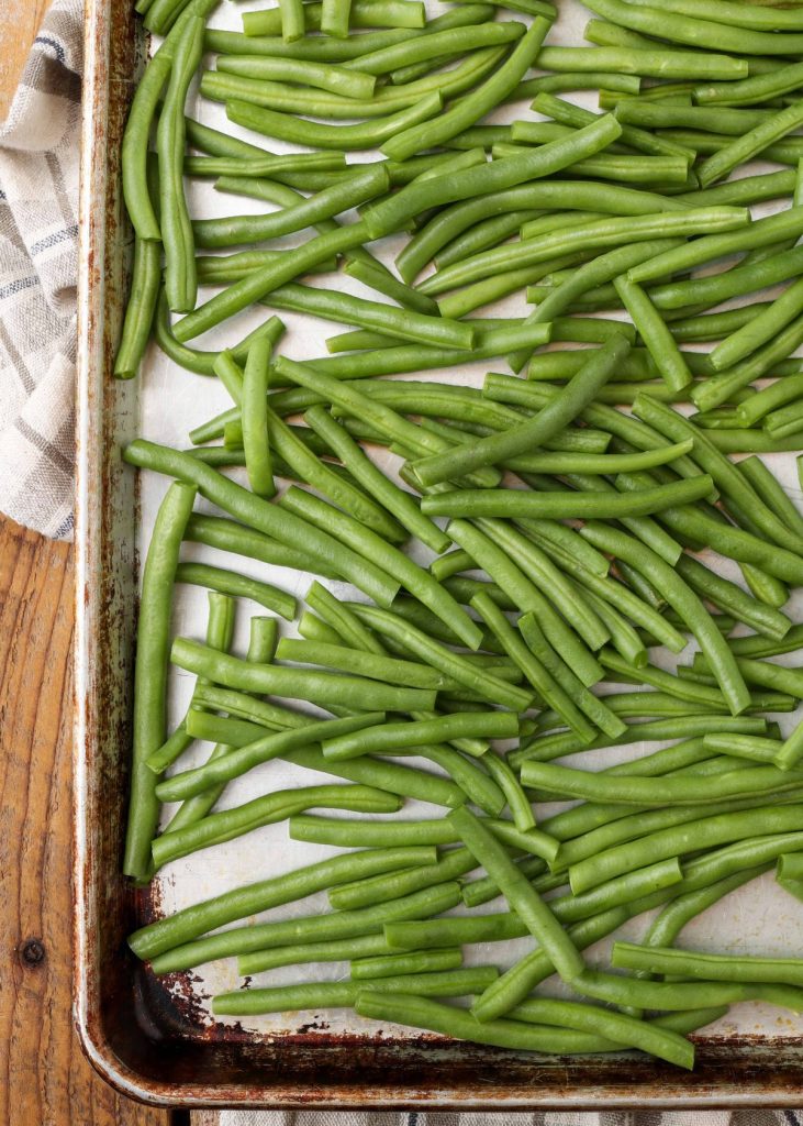 fresh green beans on baking sheet