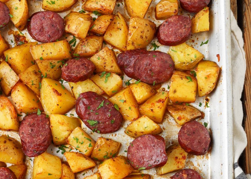 kielbasa and potatoes on sheet pan with towel